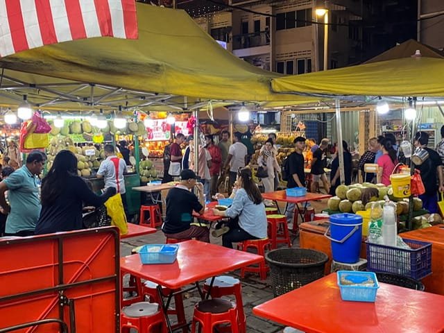 People walking and eating on Jalan Alor Food Street in Kuala Lumpur