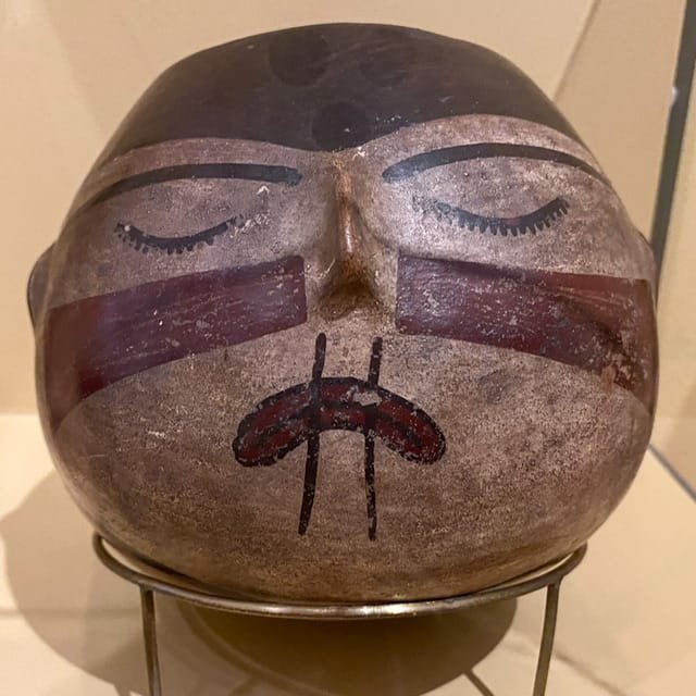 A head-shaped bowl with a face painted on it