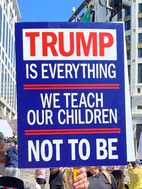 No Kings protest sign reading “Trump is everything we teach our children not to be”