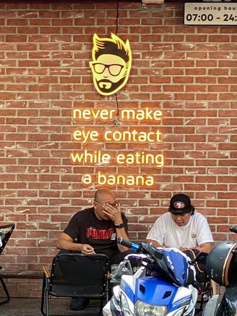 Neon letters reading “never make eye contact while eating a banana”