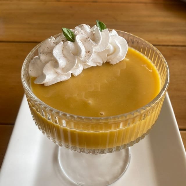 A custard dessert topped with whipped cream