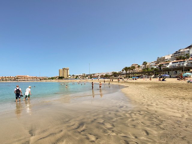 A beach with high-rise buildings in the background