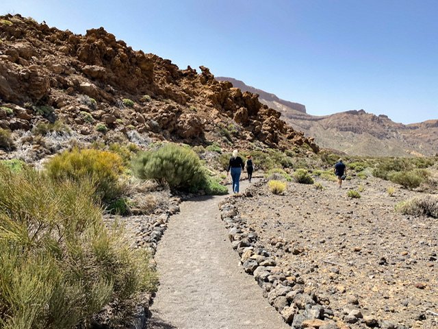 Three people hiking in rocky terrain