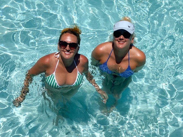 Two women standing in a swimming pool