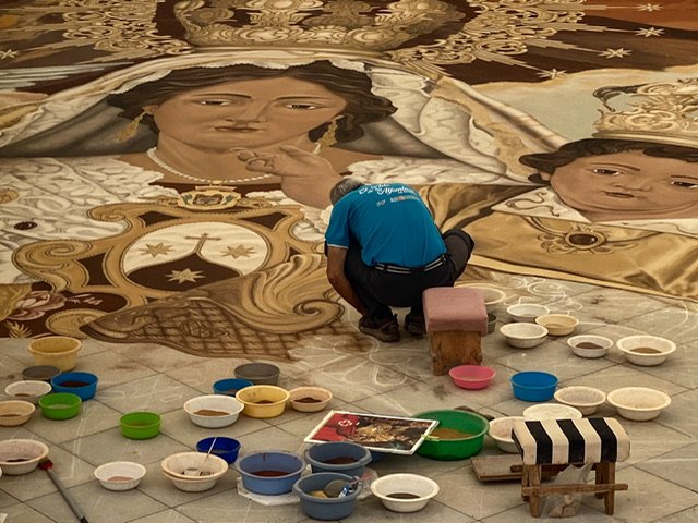 A man working on a sand painting