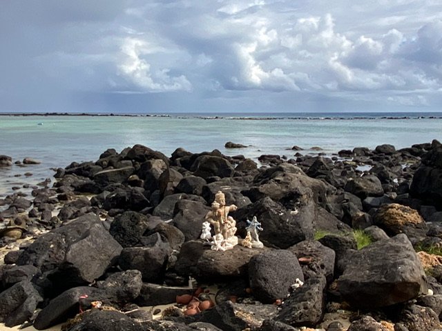 Religious figurines on rocks at the ocean’s edge