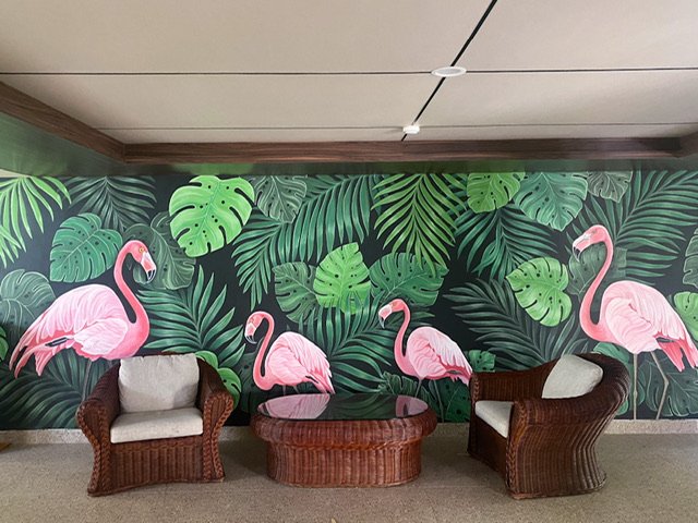 A mural of four flamingos among plants
