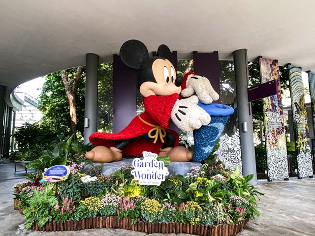 A large statue of Mickey Mouse among flowers