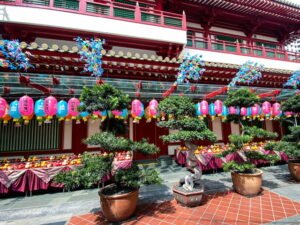 A temple exterior with lanterns and offerings